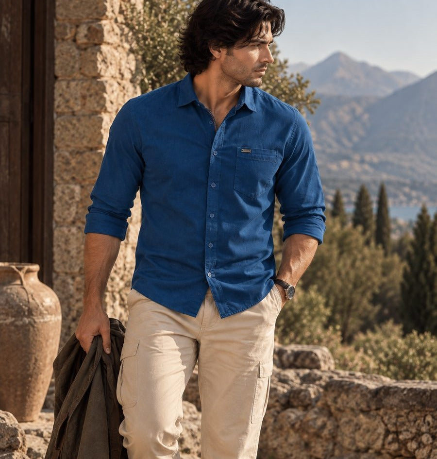 Man in a blue BRACLO shirt and beige trousers outdoors